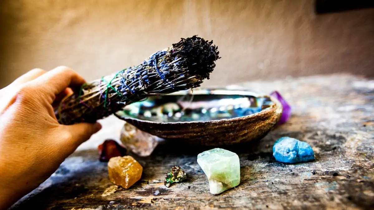burning sage held over crystals