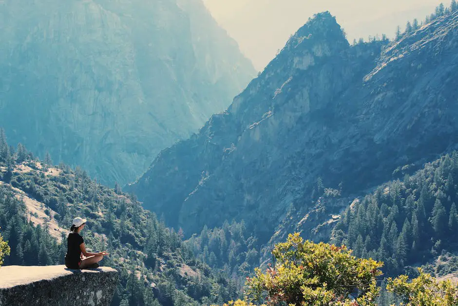 A serene image of a person meditating on a mountaintop overlooking a beautiful sunrise.